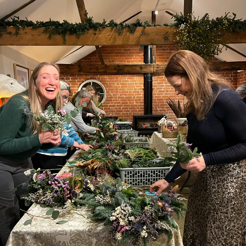 Mother and daughter holding up their Christmas wreaths they have just made a a Julian Brown Home event